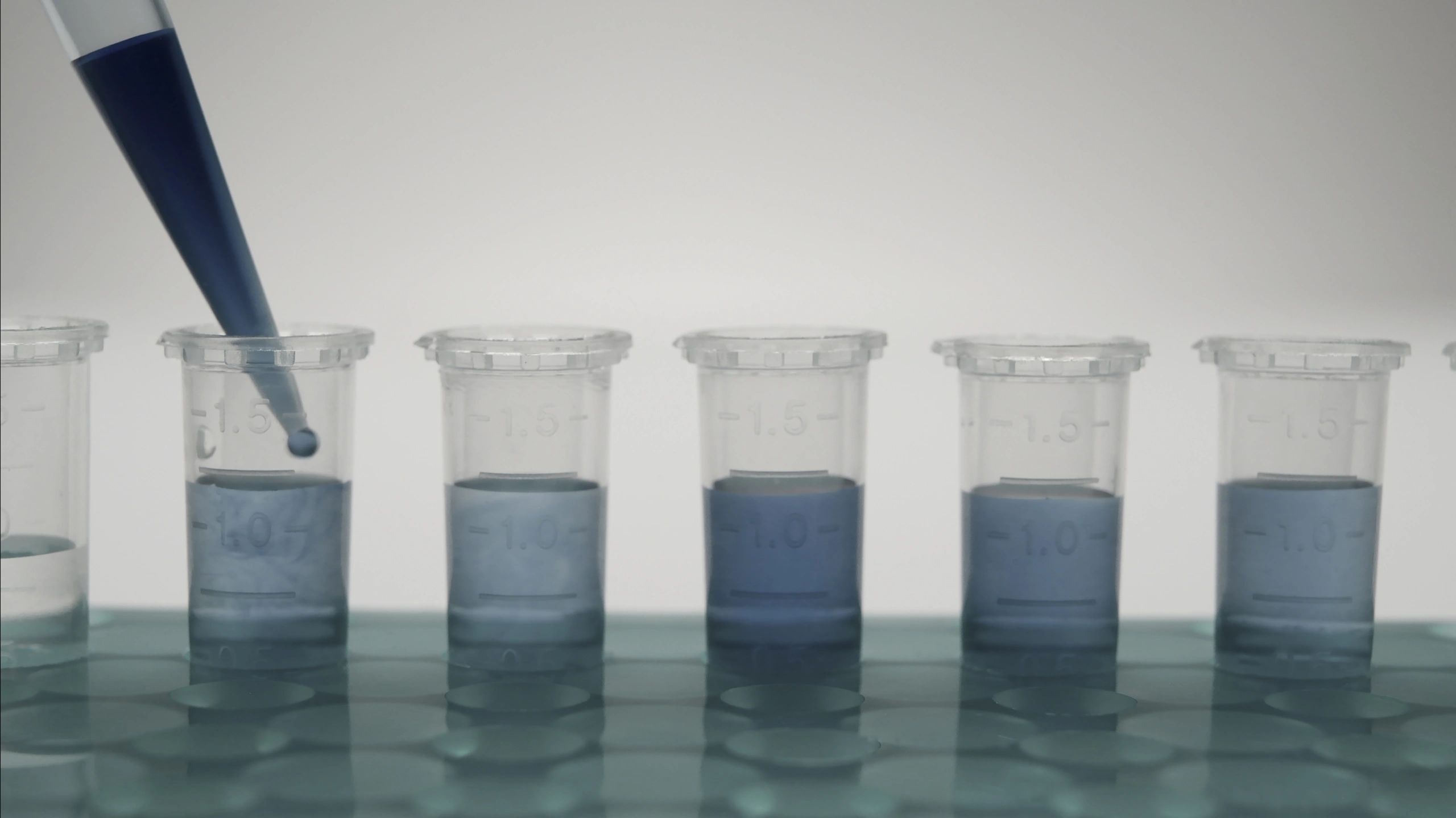 Laboratory pipette dispensing solution into microtubes with copy space